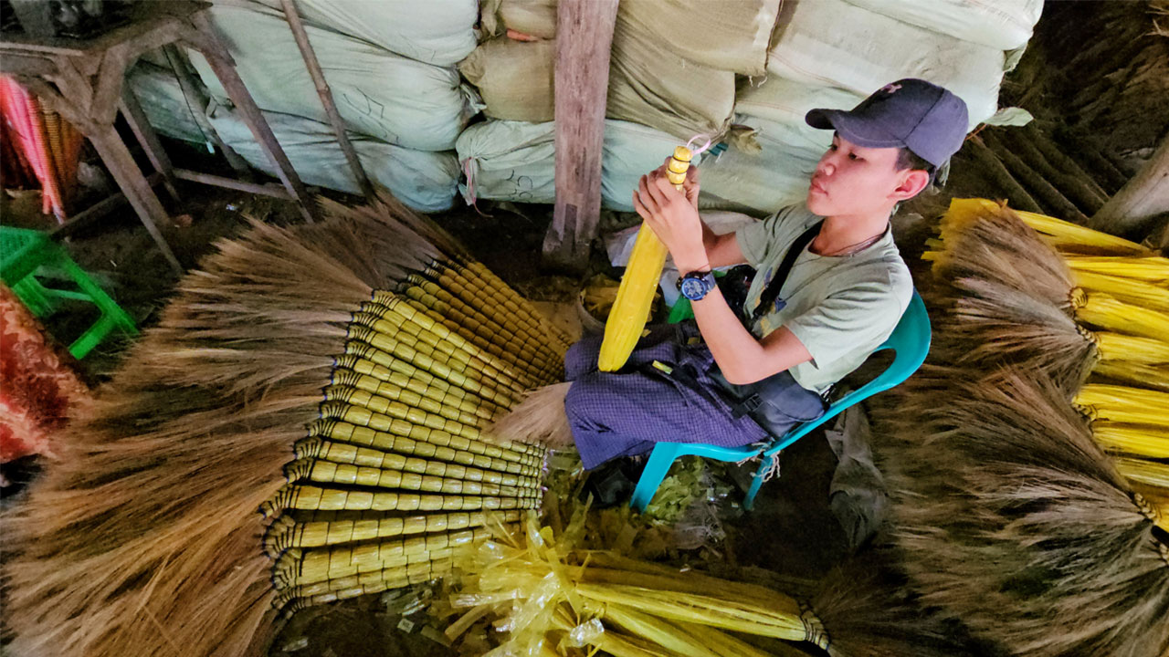 ရန်ကုန်တိုင်း၊ မှော်ဘီမြို့နယ်၊ ဝါးနက်ချောင်းစံပြကျေးရွာရှိ မြက်တံမြက်စည်းအလုပ်ရုံလုပ်ငန်းတစ်နေရာကို ၂၀၂၄ ခုနှစ်၊ ဇန်နဝါရီလ ၂၃ ရက်နေ့က တွေ့ရစဉ်။ (Photo: RFA)