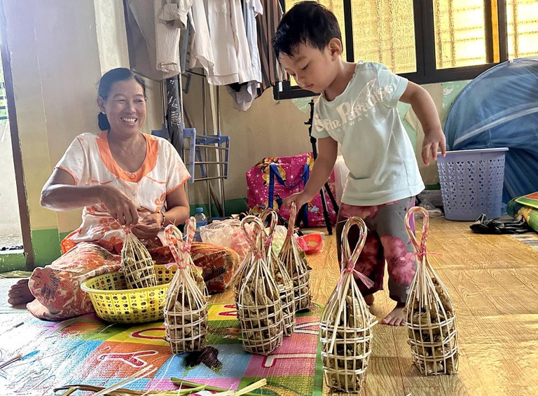 ရန်ကုန်မြို့က ခေတ္တခိုလှုံရာ နေရာတွင် ဝမ်းရေးအတွက် ငပလီကောက်ညှင်းထုပ် ပြုလုပ်နေကြသည့် ဒေါ်မြမြဝင်းတို့ မိသားစုကို ၂၀၂၄ ခုနှစ်၊ ဩဂုတ်လ ၂၇ ရက်နေ့က တွေ့ရစဉ်။ (Photo: RFA)