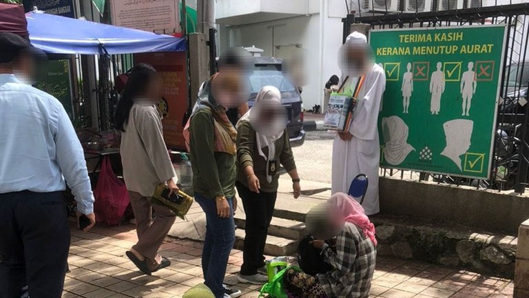 ၂ဝ၂၄ ခုနှစ် ဇန်နဝါရီလ ၁၂ ရက်နေ့က မလေးရှားနိုင်ငံ ကွာလာလမ်ပူမြို့တော်ရှိ ဗလီတစ်ခုရှေ့တွင် တောင်းရမ်းနေသူတစ်ဦးအား တာဝန်ရှိသူများက စစ်ဆေးနေစဉ်။ (Photo: Jabatan Imigresen Malaysia)