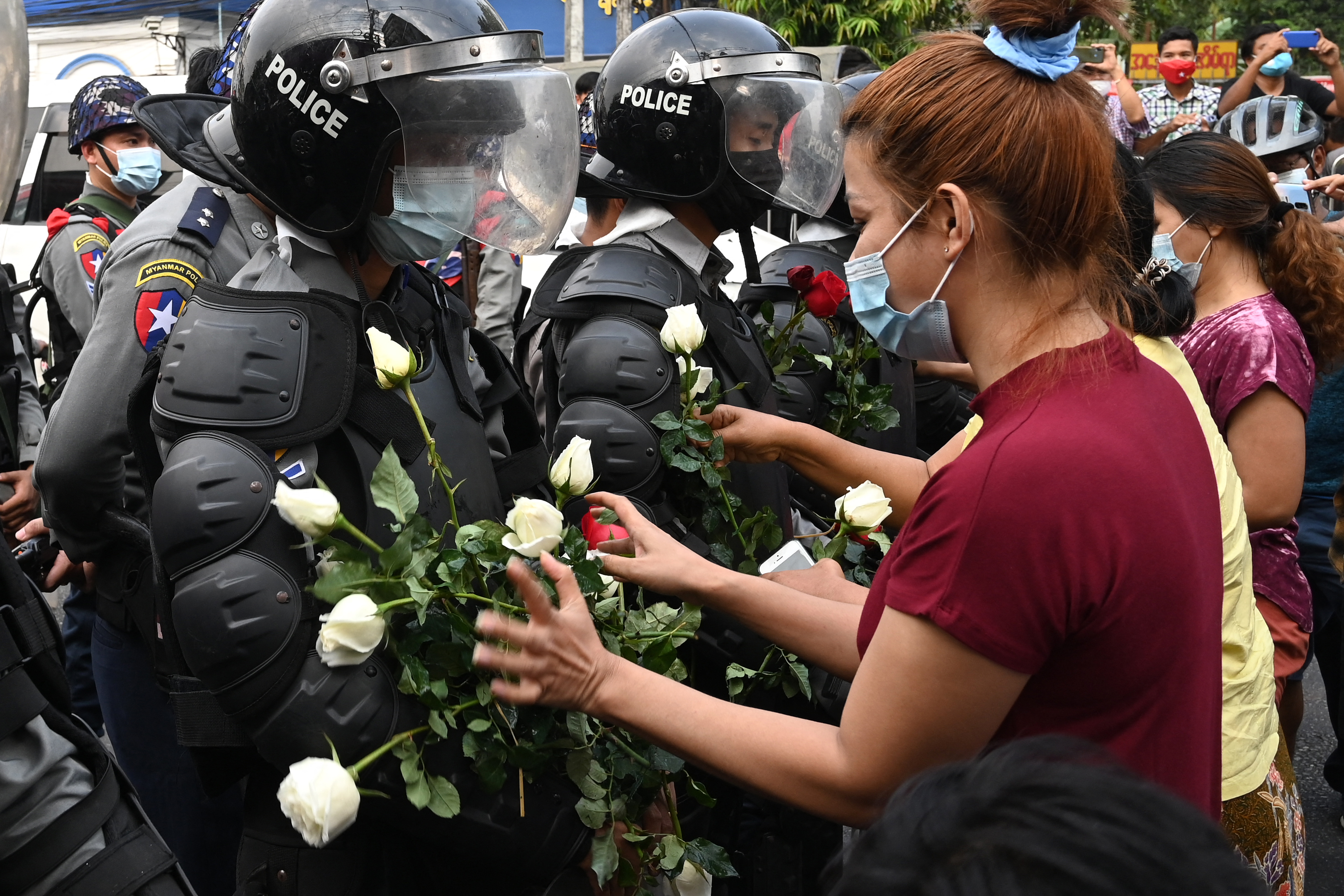 (ရန်ကုန်မှာ ၂၀၂၁ ဖေဖော်ဝါရီ ၆ ရက်နေ့က အာဏာရှင်စနစ် ဆန့်ကျင်ဆန္ဒပြသူတွေက စစ်ကောင်စီတပ်ဖွဲ့ဝင်တွေကို ပန်းပေးခဲ့စဥ်) AFP Photo