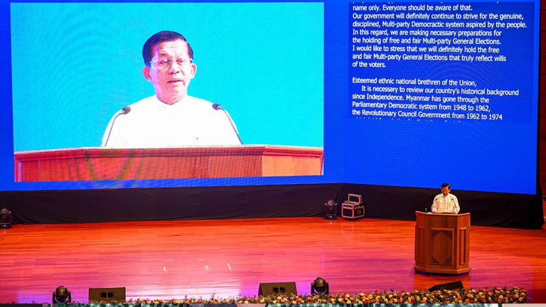 ၂၀၂၃ ခုနှစ် အောက်တိုဘာလ ၁၅ ရက်နေ့က နေပြည်တော်တွင် ပြုလုပ်သည့် တစ်နိုင်ငံလုံး အပစ်အခတ်ရပ်စဲရေး သဘောတူစာချုပ် (NCA) ရှစ်နှစ်မြောက် အခမ်းအနားတွင် ဗိုလ်ချုပ်မှူးကြီး မင်းအောင်လှိုင်က မိန့်ခွန်းပြောကြားစဉ်။ Photo : AFP