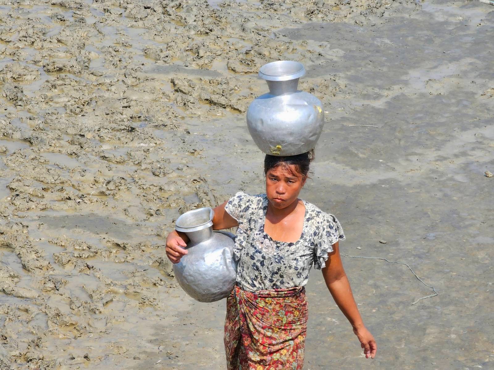 ရခိုင်ပြည်နယ်၊ စစ်တွေမြို့နယ်၊ ကျေးတောပိုက်ဆိပ်ကျေးရွာမှ သောက်သုံးရေကန်တစ်ကန်မှာ ရေလာခပ်သူတစ်ဦးအား ၂၀၂၃ ခုနှစ်၊ မေလ ၂၂ ရက်နေ့က တွေ့ရစဉ်။ (Photo: RFA)