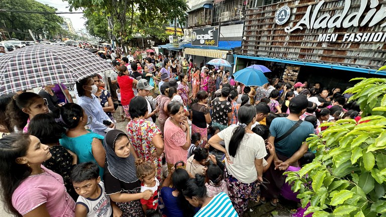 ၂၀၂၃ ခုနှစ် သြဂုတ်လ ၂၇ ရက်နေ့က ရန်ကုန်တိုင်း သင်္ဃန်းကျွန်းမြို့နယ် လေးထောင့်ကန်လမ်းမပေါ်မှာ ဆန်နဲ့ ကြက်ဥ ဈေးလျှော့ရောင်းတာကို လာရောက်ဝယ်ယူသူများကို တွေ့ရစဉ်။