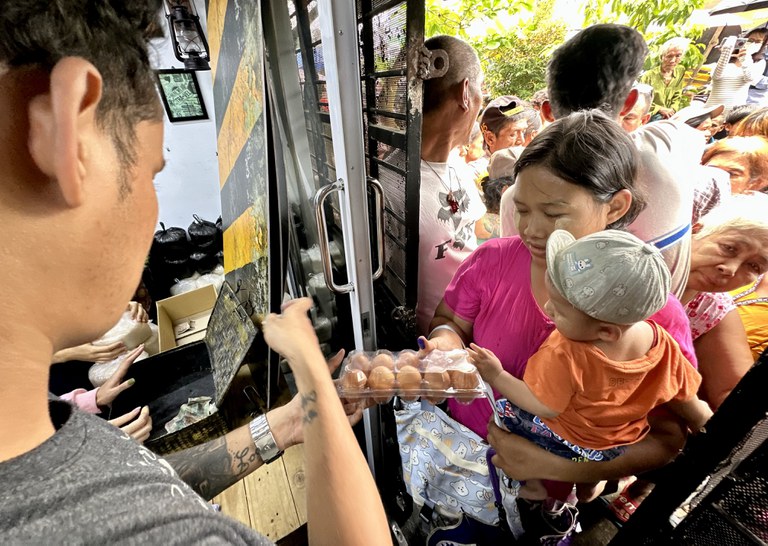 ၂၀၂၃ ခုနှစ် သြဂုတ်လ ၂၇ ရက်နေ့က ရန်ကုန်တိုင်း သင်္ဃန်းကျွန်းမြို့နယ် လေးထောင့်ကန်လမ်းမပေါ်မှာ ဆန်နဲ့ ကြက်ဥ ဈေးလျှော့ရောင်းတာကို လာရောက်ဝယ်ယူသူတစ်ဦးကို တွေ့ရစဉ်။