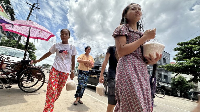 ၂၀၂၃ ခုနှစ် သြဂုတ်လ ၂၇ ရက်နေ့က ရန်ကုန်တိုင်း သင်္ဃန်းကျွန်းမြို့နယ် လေးထောင့်ကန်လမ်းမပေါ်မှာ ဆန်နဲ့ ကြက်ဥ ဈေးလျှော့ရောင်းတာကို လာရောက်ဝယ်ယူသူများကို တွေ့ရစဉ်။