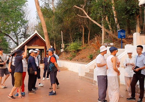 ນັກທ່ອງທ່ຽວຊາວຈີນຢືນພັກຜ່ອນ ພາຍຫຼັງທີ່ທ່ຽວຊົມນະຄອນຫຼວງພຣະບາງ (TS), ເດືອນມີນາ 2024.