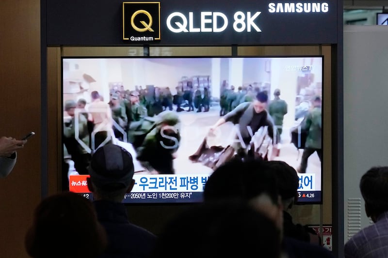 韩国首尔市火车站的新闻画面显示,一些据信是朝鲜士兵的军人,排队领取俄军提供的军事装备。(美联社图片)