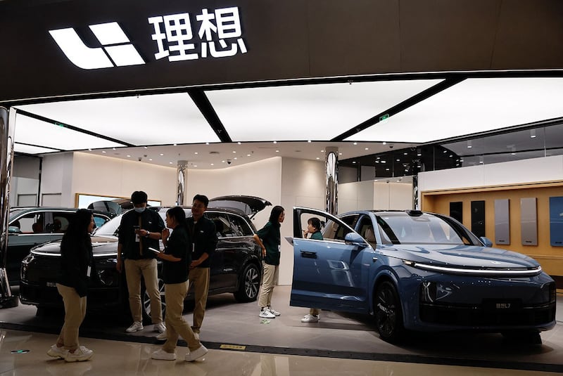 2023年11月3日,北京购物中心,工作人员在理想汽车展台前。(路透社)