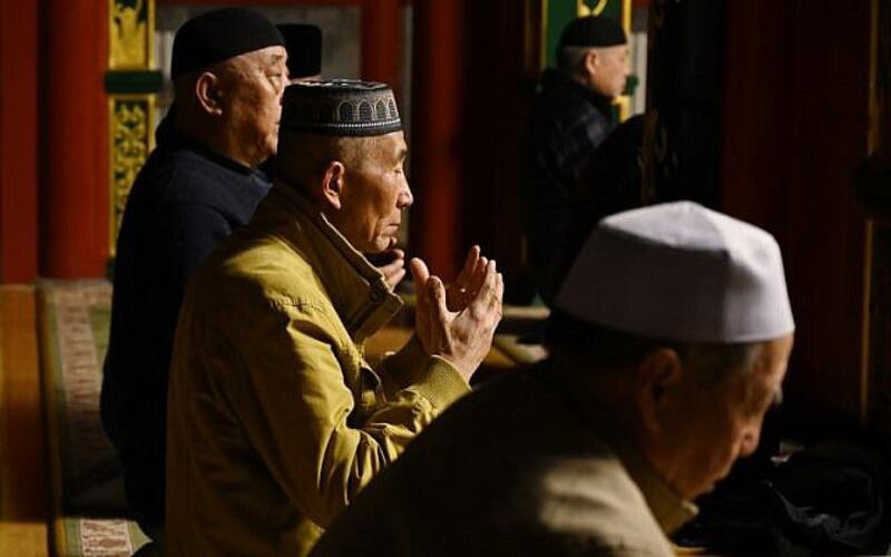 资料图片:2019年3月18日,维吾尔穆斯林男子在北京的一座清真寺祈祷。(法新社)