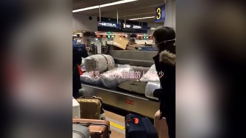 北京国际机场行李传送带上,众多海外华人抵达。(视频截图)
