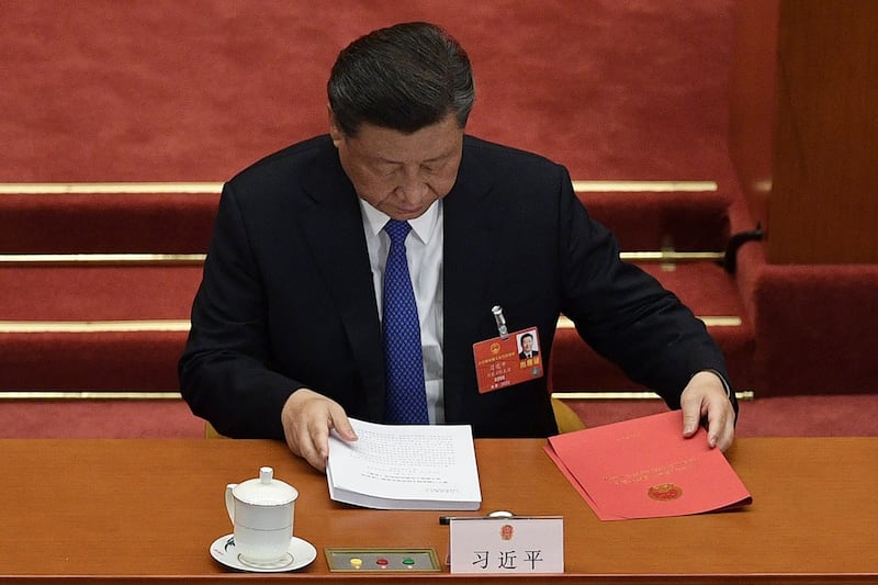 图为，2020年5月28日，习近平在北京人民大会堂举行的全国人民代表大会闭幕会议时准备文件。（法新社）