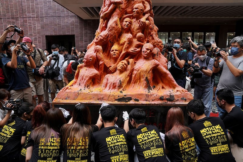 2021 年 6 月 4 日,香港,纪念六四32 周年之际,大学生正在清理香港大学的“耻辱柱”雕像。(路透社)