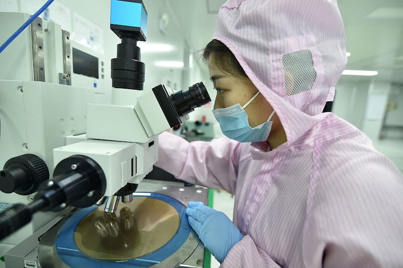 2023年2月28日,一名员工在中国江苏省宿迁市一家半导体芯片公司的生产线上检查晶圆。(路透社图片)