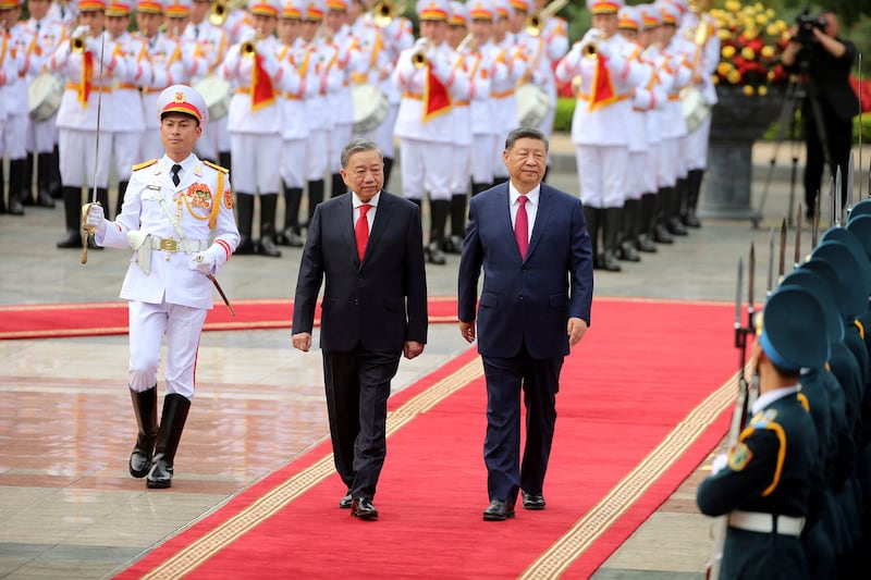 Vietnamese General Secretary of the Communist Party To Lam and Chinese President Xi Jinping review the guard of honor at the Presidential Palace in Hanoi, Vietnam, April 14, 2025.