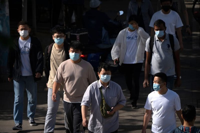 2023年5月23日,北京街道上的行人戴上了口罩。(美联社图片)