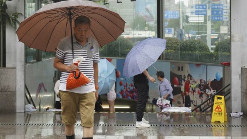 中国南方连续降雨,图为上海居民在雨中出行。(美联社)