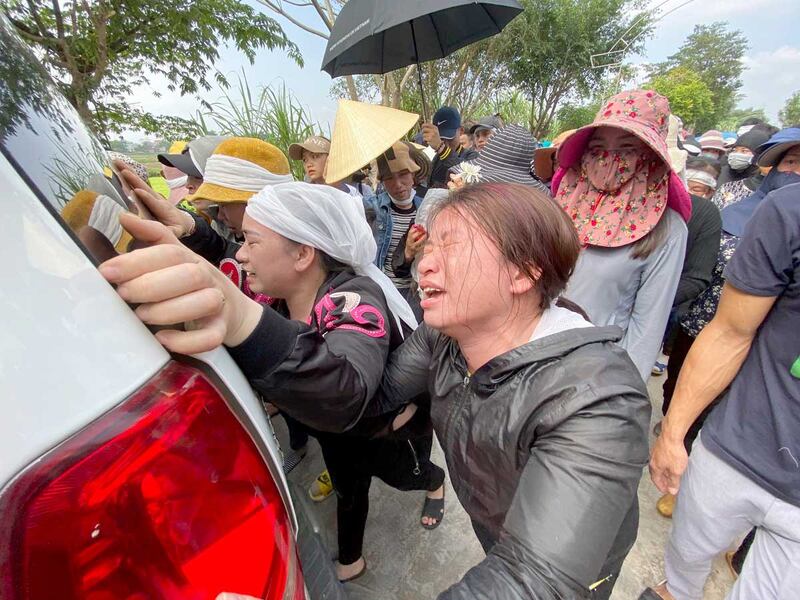 The sisters of Bui Thi Nhung weep as they walk behind the ambulance carrying Nhung's casket on Nov. 30, 2019 in the village of Do Thanh, Vietnam. The body of 19-year-old Nhung was among the last to be repatriated. (Associated Press)