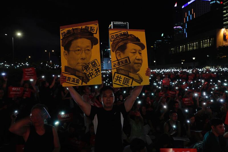 2019年6月26日,在香港集会上抗议者手持标牌“习近平与韩正画像”。(美联社)