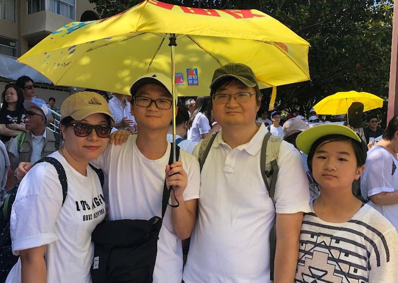 港人郭小峰一家四口打着2014年“占中”雨伞参加“反送中”集会(CK拍摄)