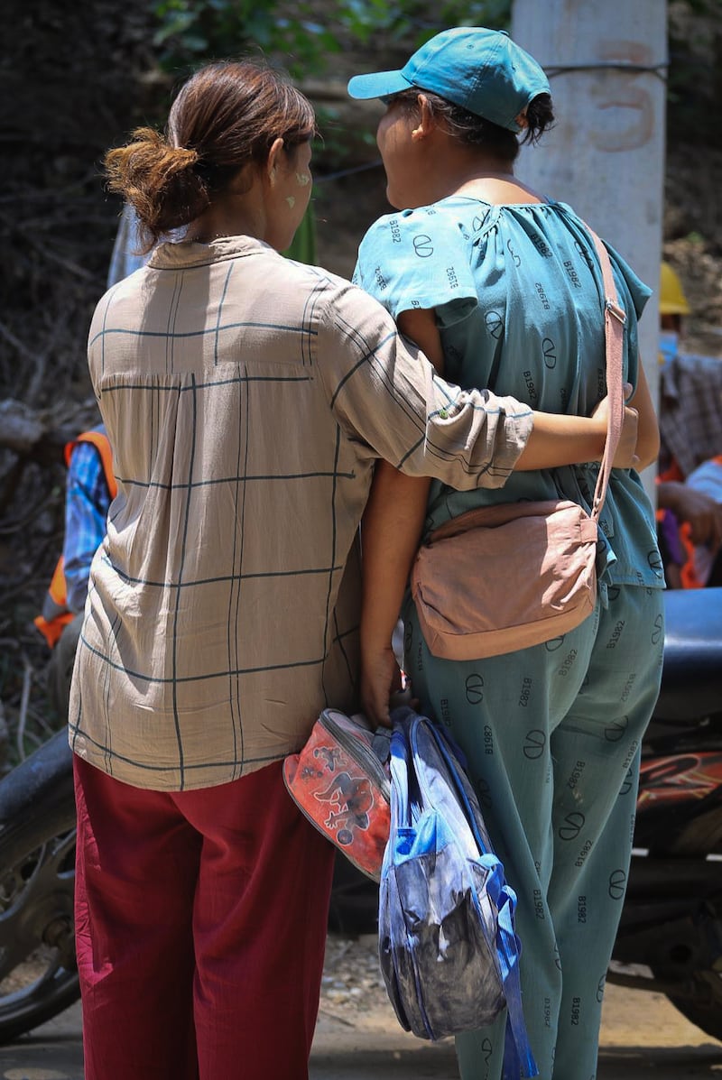 Family members as they collect the belongings of children at a destroyed pre-school in Sagaing city, Myanmar, on April 24, 2025, four weeks after Myanmar's devastating earthquake.
