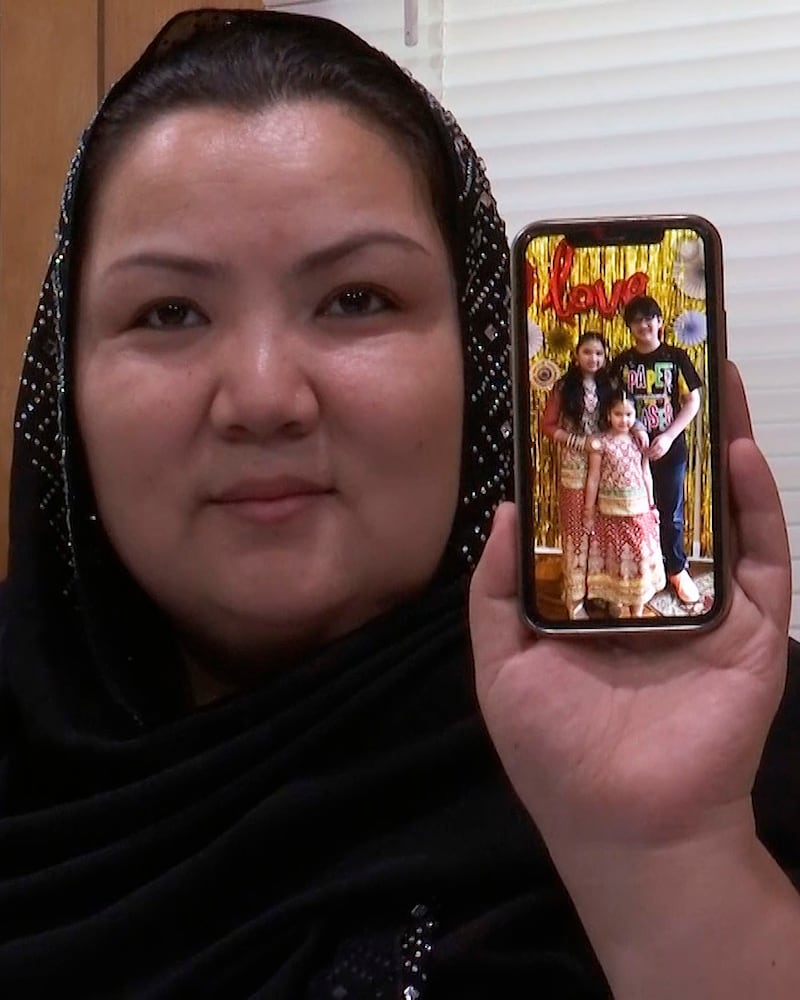 来自新疆的维吾尔人Zumret Dawut在美国弗吉尼亚的家里展示手机上她的孩子照片。(美联社)