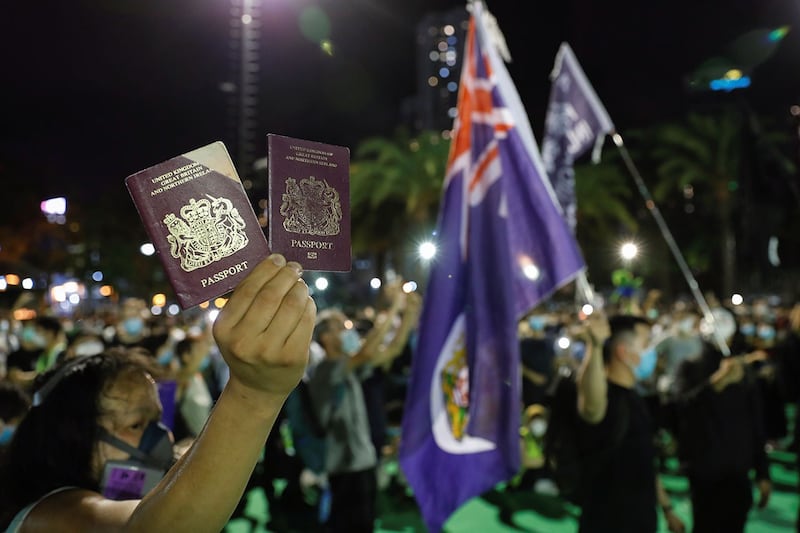 2020 年 6 月 4 日,一名香港示威者手举英国国民海外护照(BNO)。(路透社)