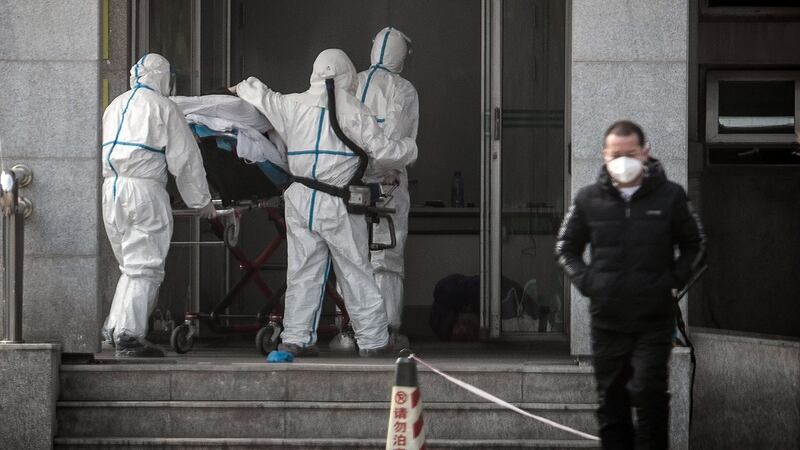 2020年1月18日,医务人员将一名感染患者送往武汉市金银潭医院。(法新社)