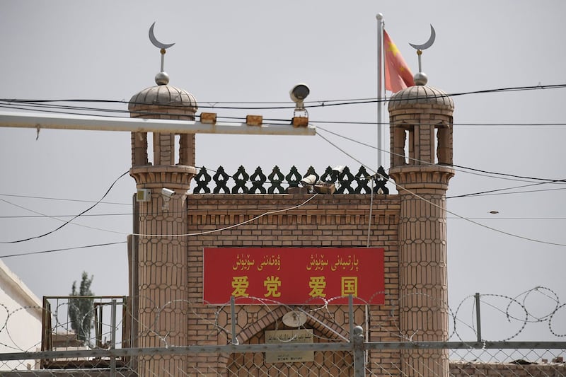 2019年6月4日,在新疆喀什市一座清真寺入口上面写着“爱党爱国”标语。(法新社)