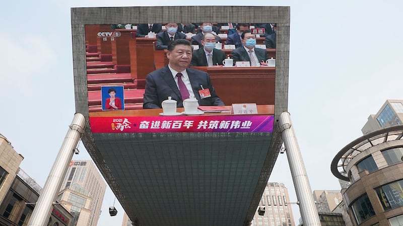 2021 年 3 月 11 日,北京街头一个大屏幕播放着习近平的画面。(美联社)