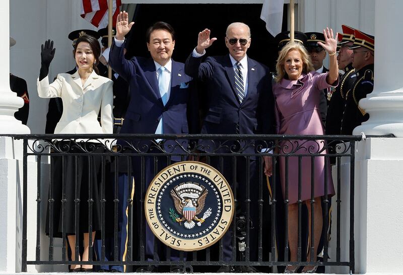 2023年4月26日,在美国华盛顿白宫,韩国总统尹锡悦(左二)夫妇和美国总统拜登(右二)夫妇站在阳台上挥手致意。(路透社)