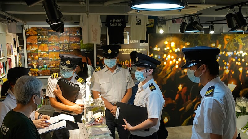 2021 年 6 月 1 日,香港食物环境卫生署官员在支联会的“六四纪念馆”里,对工作人员查询。(美联社)