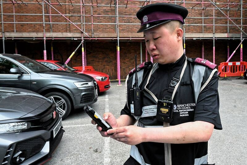 梁铭康年初移居英国曼彻斯特后,放下拿了六年多的照相机,转而穿起制服、拿起对讲机,成为一名交通督导员,专责向违例停车者发告票。 (梁铭康提供)