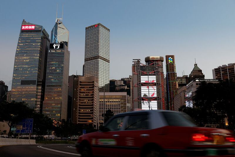 2021 年 8 月 17 日,一辆出租车在香港中央商务区的国际金融中心的摩天大楼前行驶。(路透社)