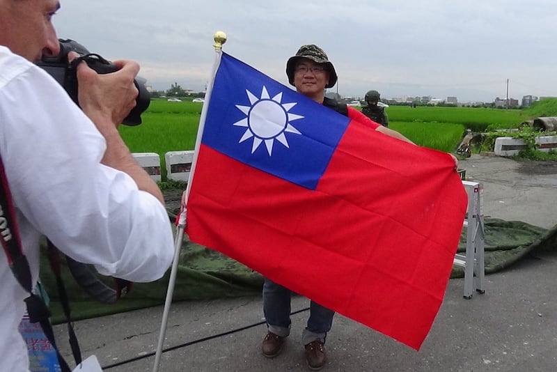 来自台北的吴启豪,就带着巨幅青天白日旗到现场制高点,引发法国媒体费加洛报拍摄。(记者夏小华摄)