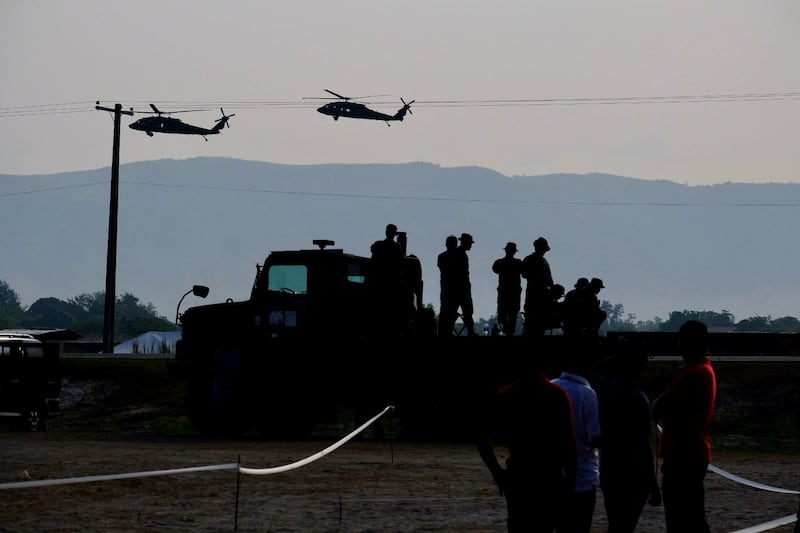 Two helicopters fly over U.S. troops during live-fire joint military exercises between the Philippines and the United States, in Zambales province, Philippines, April 26, 2023.