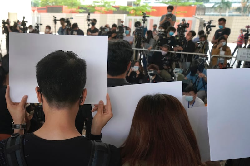 Journalists photograph supporters of Hong Kong journalist Choy Yuk-ling holding signs outside a court in Hong Kong, April 22, 2021.