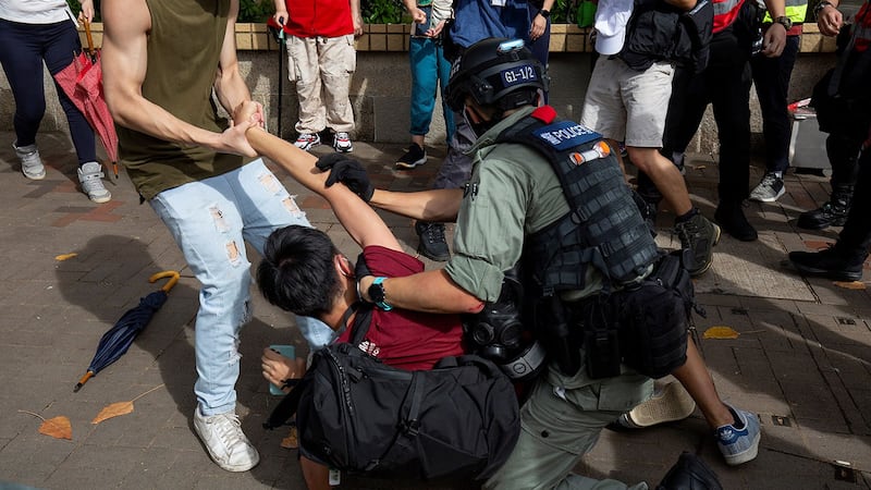 2020年7月1日,香港举行抗议国安法,一名防暴警察试图抓捕一名男子。(AFP)
