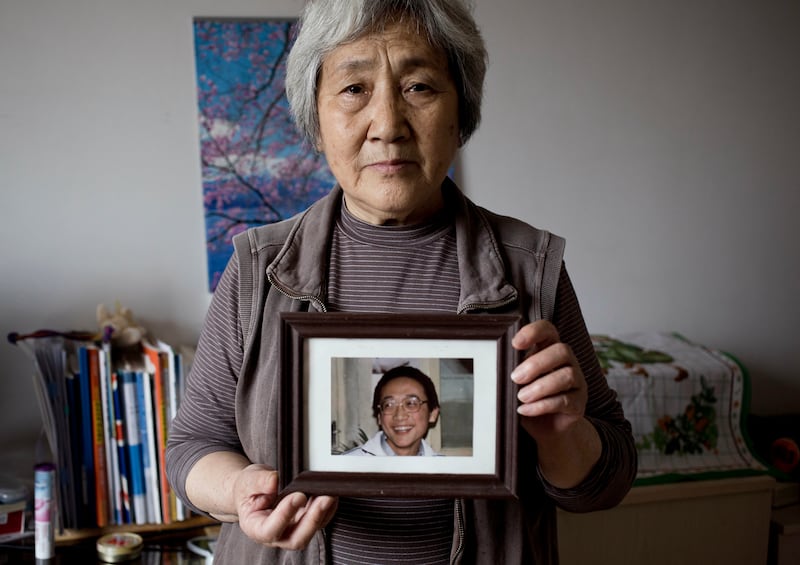In this April 29, 2014 photo, Zhang Xianling holds up a photo of her son Wang Nan who was killed during the 1989 Tiananmen military crackdown in Beijing, China.