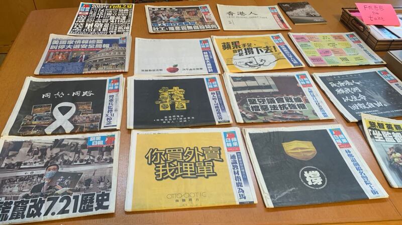 在“香港人会馆”总部的会议桌上,摆放着《苹果日报》与香港抗争相关的新闻报道。(孙诚拍摄)