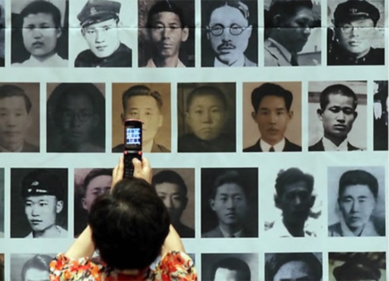  '제4회 6.25 납북희생자 기억의 날' 기념식에서 참가 가족이 납북희생자들의 인물사진 현수막을 촬영하고 있다. 