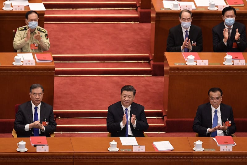 2020年5月28日,在北京人民大会堂举行的全国人民代表大会,习近平(中),李克强(右)和汪洋(左)对起草香港安全法的提案进行投票后。(法新社)