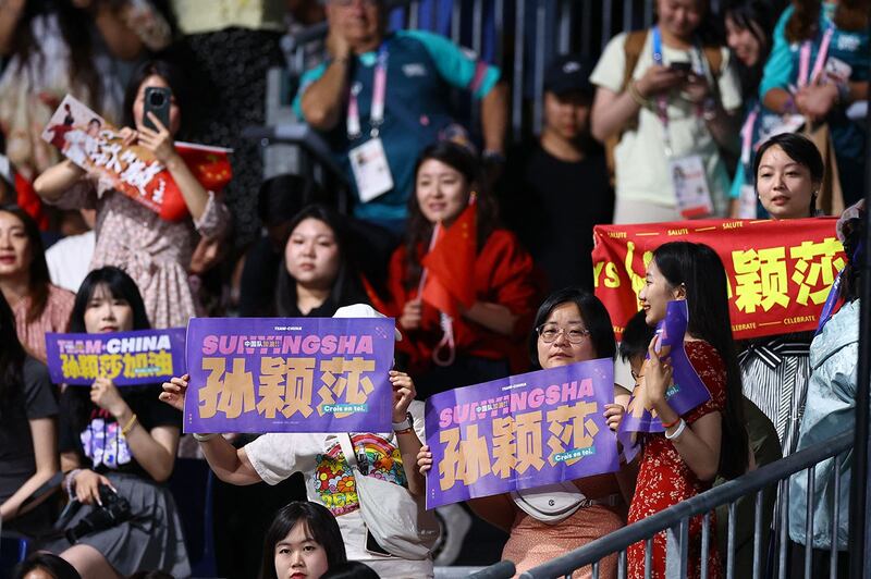 2024年8月3日,中国选手陈梦在巴黎奥运乒乓球女单决赛中对阵队友孙颖莎,多名观众举牌为孙颖莎加油。(路透社)
