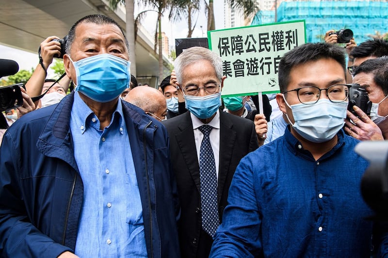 2020年5月18日,香港民主党创党主席李柱铭(中)、壹传媒创办人黎智英(左)抵达西九龙裁判法院出庭,他们被控组织及非法参与未经批准的集会游行。(法新社图片)