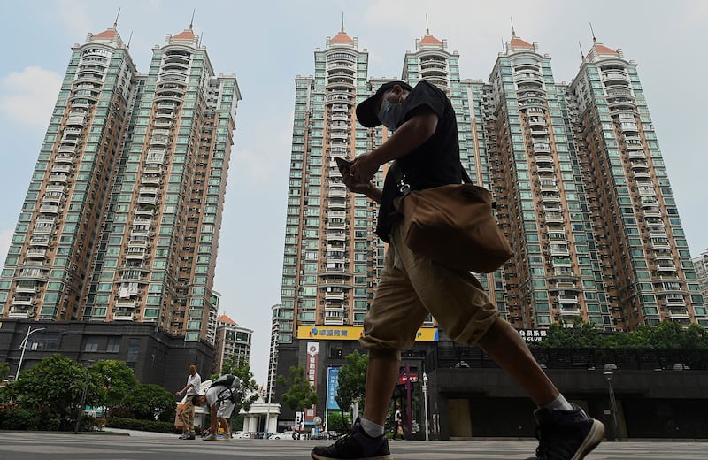 一名男子走过广州市恒大的住宅区。 (法新社)