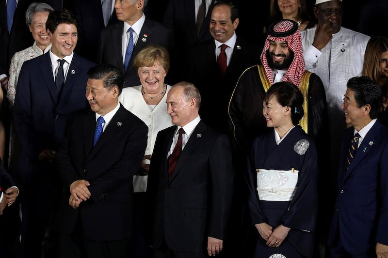 2019年6月28日在大阪举行的G20峰会期间,,(LtoR)加拿大总理特鲁多,中国国家主席习近平,德国总理默克尔,俄罗斯总统普京,日本首相安倍晋三和他的妻子阿基以及沙特王储穆罕默德·本·萨勒曼合影。(法新社)